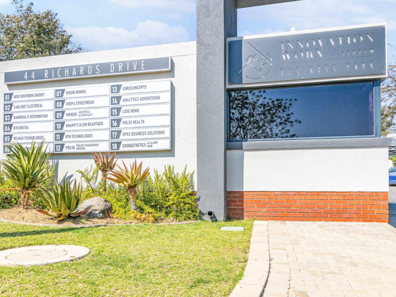 entrance signage at innovation worx - business park, showing the building name and tenant company signs