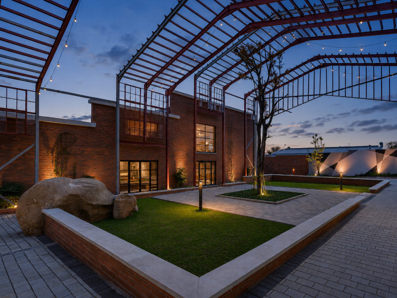 night view inside innovation worx - richards drive, showing the seating area with a tree in the centre